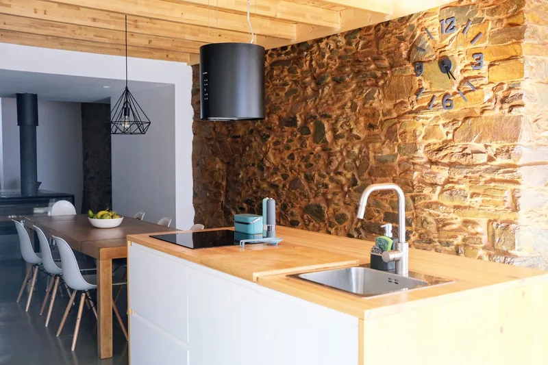 Cozinha equipada com parede de pedra
